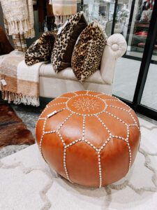 A fireplace mantle with two mirrors and some vases