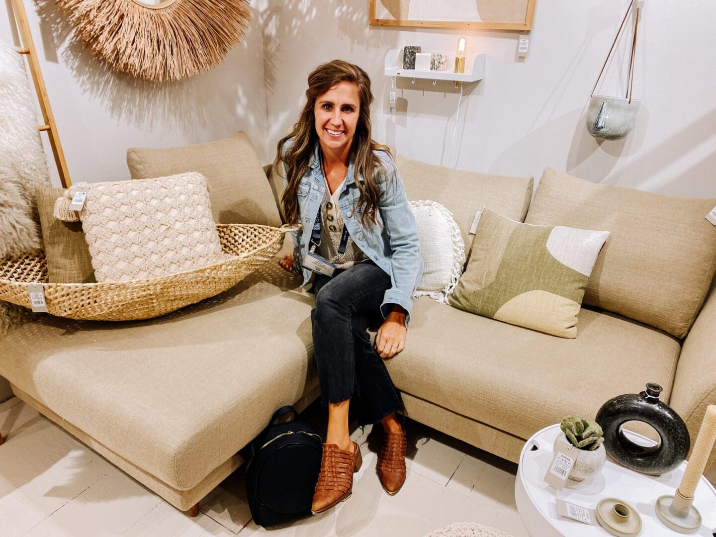 A woman sitting on top of a couch in front of a pillow.